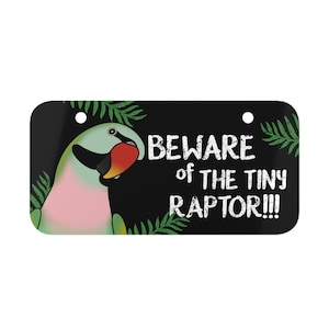 以下が含まれることがあります： オウムのイラストと「Beware of the Tiny Raptor!!!」というテキストが書かれた黒と緑の看板