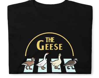May include: Black t-shirt with a graphic of four geese walking across a crosswalk. The geese are in a line, and the graphic is in a circle with the text "THE GEESE" above the geese.