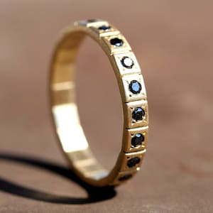 Anillo de eternidad de oro amarillo con diamantes negros