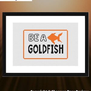 May include: Cross stitch pattern for a framed design that says "Be a Goldfish" with an orange goldfish illustration. The pattern is 6.0 inches by 3.9 inches and uses 2 DMC colors.