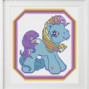 Peut inclure: Un motif de point de croix repr&eacute;sentant un poney bleu et violet avec une crini&egrave;re et une queue arc-en-ciel. Le poney est entour&eacute; d'un cadre octogonal multicolore.