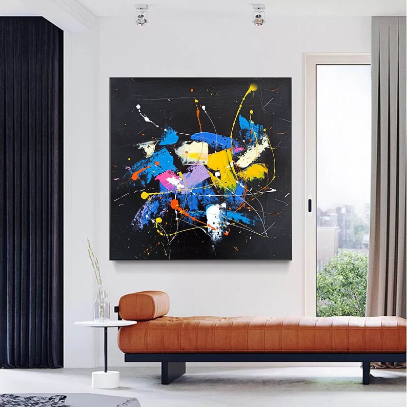 Abstract painting with splashes of blue, yellow, pink, and white paint on a black background.