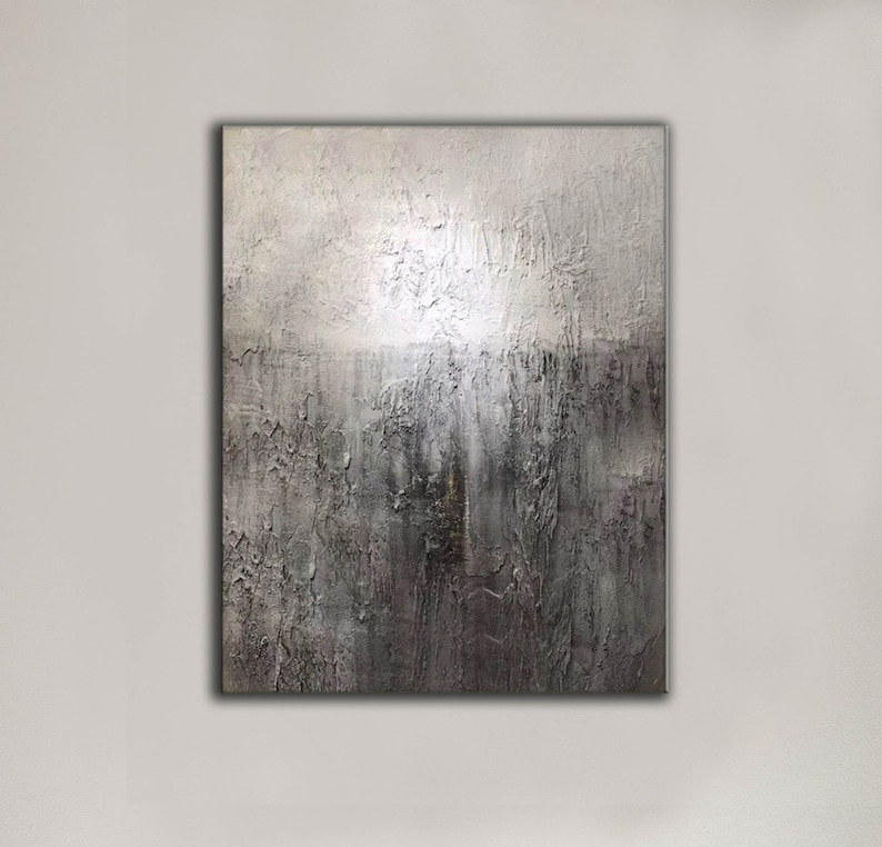 May include: Abstract painting with a textured surface. The painting is in shades of gray and white, with a darker gray area at the bottom. The texture of the paint creates a sense of depth and movement.