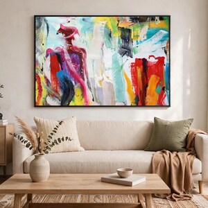 Puede incluir: Una gran pintura abstracta rectangular con pinceladas audaces y expresivas en tonos vibrantes de rojo, amarillo, azul y blanco. La obra de arte est&aacute; enmarcada con un borde negro fino y cuelga horizontalmente en una pared de color neutro.
