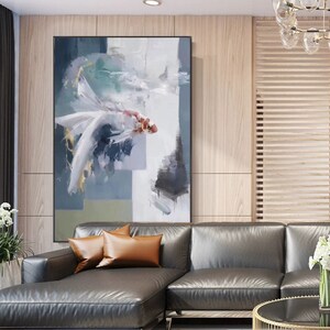 Puede incluir: Pintura abstracta de un pez blanco con acentos rojos y dorados sobre un fondo azul y verde. La pintura est&aacute; enmarcada en negro y colgada en una pared.