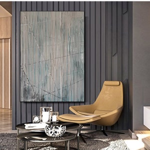 May include: Abstract art print with a blue and white striped pattern. The print is framed and hanging on a gray wall in a modern living room.