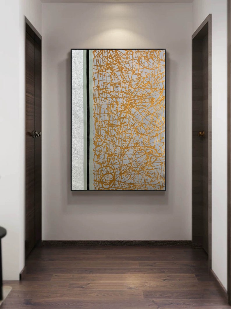 K&ouml;nnte beinhalten: Abstrakter Kunstdruck mit wei&szlig;em Hintergrund und goldenen Linien. Der Druck hat einen schwarzen und wei&szlig;en vertikalen Streifen auf der linken Seite.