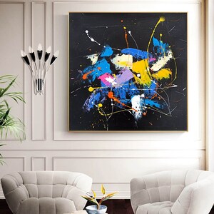 May include: Abstract painting with a black background and colorful splashes of blue, yellow, pink, and orange paint. The painting has a modern and contemporary style.