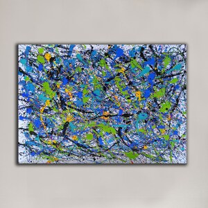 May include: Abstract painting with a white background and a variety of colours including black, blue, green, yellow, and orange. The paint is applied in a splatter technique, creating a dynamic and energetic composition.