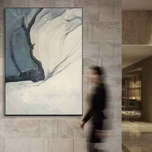 May include: Abstract painting with a blue and white color scheme. The painting features a large, flowing shape in the center, with smaller shapes and lines surrounding it.