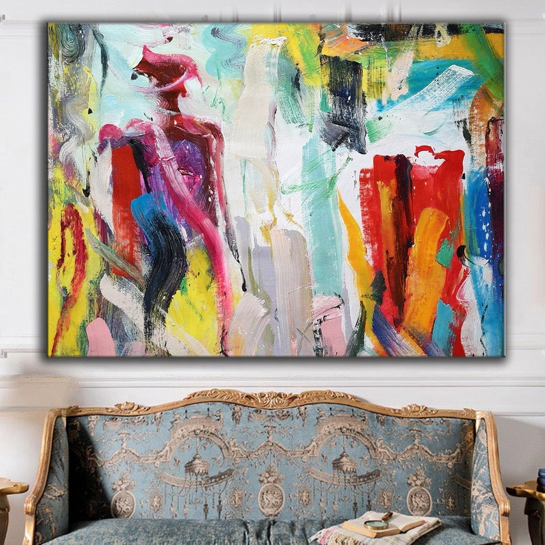 Abstract painting with colorful brushstrokes in shades of red, yellow, blue, green, pink, and white. The painting has a textured surface and is displayed on a wall above a couch.