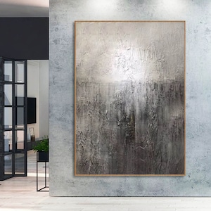 May include: Abstract painting with a textured, gray and white color scheme. The painting is framed in a thin, wooden frame.