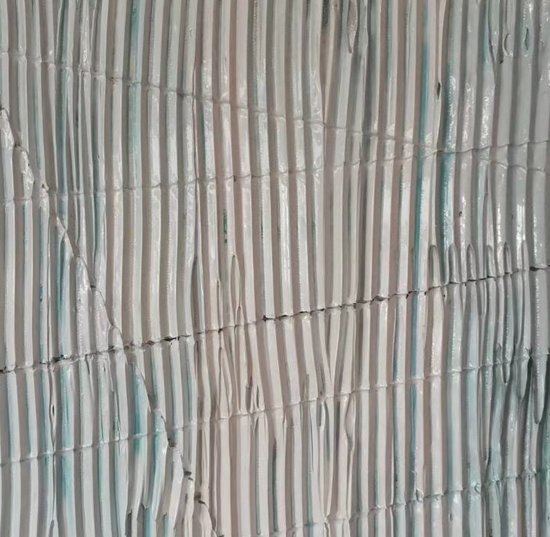 May include: A close-up of a textured wall with vertical lines in shades of white and light blue. The lines are arranged in a pattern that creates a sense of depth and dimension.