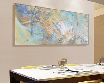 May include: Abstract painting with a blue, white, and yellow color scheme. The painting is framed in a gold frame and is hanging on a wall in a dining room.