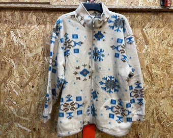 May include: Cream-colored fleece jacket with a full zipper and a high collar. The jacket features a repeating pattern of blue and brown geometric shapes. The jacket is a medium size and appears to be made of a soft, warm material.
