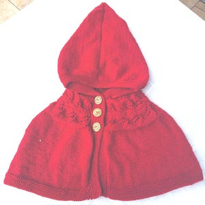 Elegant Little Red Riding Hood cape with leaf pattern for children aged 2 to 5, knitted from a soft red polyacrylic blend.