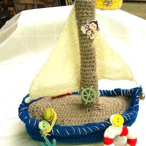Velero de crochet con ancla, mono, chancla, bandera y volante.