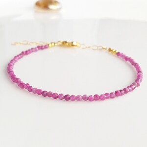 Puede incluir: Un delicado brazalete de piedras preciosas rosas con cierre dorado. El brazalete está hecho de pequeñas cuentas facetadas y es perfecto para el uso diario.