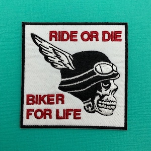 May include: White embroidered patch featuring a black and white skull wearing a helmet with wings. The text "Ride or Die" and "Biker for Life" is in red.