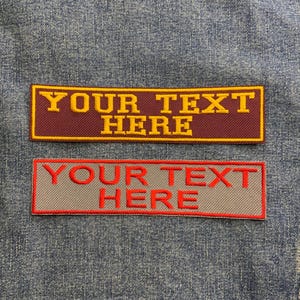 May include: Two rectangular fabric patches with a red and grey background. The top patch has yellow text that reads "YOUR TEXT HERE". The bottom patch has red text that reads "YOUR TEXT HERE".