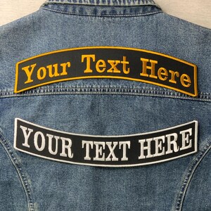 May include: A denim jacket with two embroidered patches. The top patch is black with yellow text that reads "Your Text Here". The bottom patch is black with white text that reads "YOUR TEXT HERE".