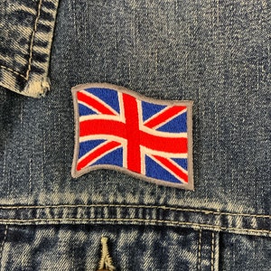 May include: A blue denim jacket with an embroidered Union Jack flag patch on the front.