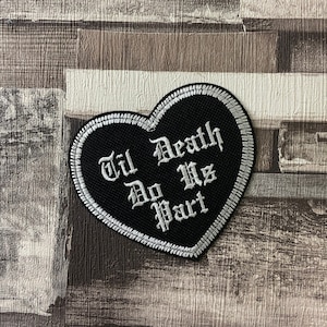 May include: Black heart-shaped patch with white embroidered text that reads "Til Death Do Us Part".