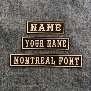 May include: Three black and white embroidered patches with white text on a black background. The top patch says "NAME", the middle patch says "YOUR NAME", and the bottom patch says "MONTREAL FONT".