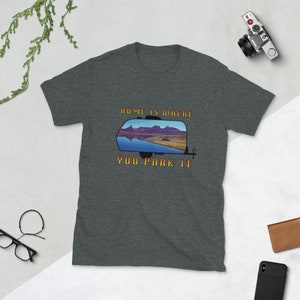 Puede incluir: Una camiseta gris oscuro jaspeada con un gráfico de una caravana con el texto "Home is where you park it".