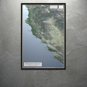 Könnte beinhalten: Eine gerahmte Karte der Redwood Empire Region an der kalifornischen Küste. Die Karte zeigt eine detaillierte Luftaufnahme der Küste mit verschiedenen markanten Punkten und geografischen Merkmalen, die beschriftet sind. Der Titel "Redwood Empire California Coast" ist unten auf der Karte gedruckt.
