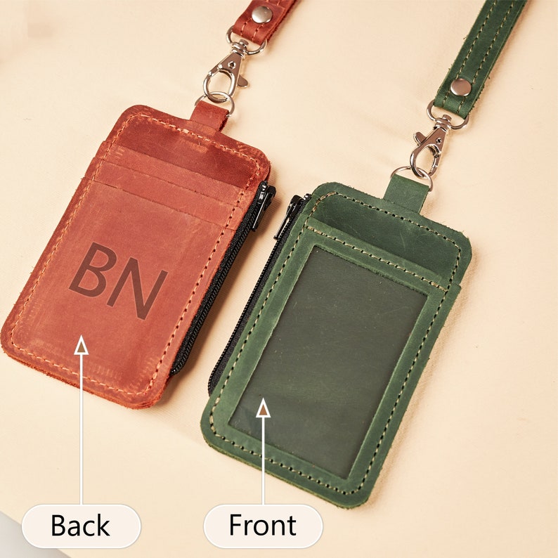 Puede incluir: Dos porta-identificaciones de cuero con cordones. Uno es marrón con las iniciales 'BN' y el otro es verde con una ventana transparente para una foto. Ambos tienen un bolsillo con cremallera.