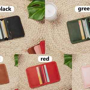 May include: Five leather card holders in different colors: black, green, cognac, red, and pink. Each holder has multiple card slots and is open to reveal the cards inside.