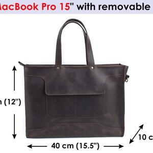 K&ouml;nnte beinhalten: Eine braune Ledertasche mit Rei&szlig;verschluss und abnehmbarem Trageriemen. Die Tasche ist 40 cm breit, 30 cm hoch und 10 cm tief.