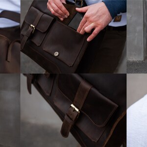 May include: A brown leather messenger bag with two front pockets and a buckle closure. The bag has a long adjustable strap and a top handle.