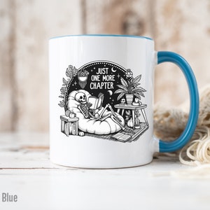 Light blue accent coffee mug with skeleton reading while lounging in a boho style room with the words Just One More Chapter