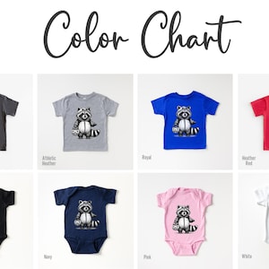 May include: Color chart showing different color options for a baby onesie and t-shirt featuring a black and white illustration of a raccoon wearing a costume. The onesie and t-shirt are available in colors such as asphalt, athletic heather, royal, heather red, black, navy, pink, and white.