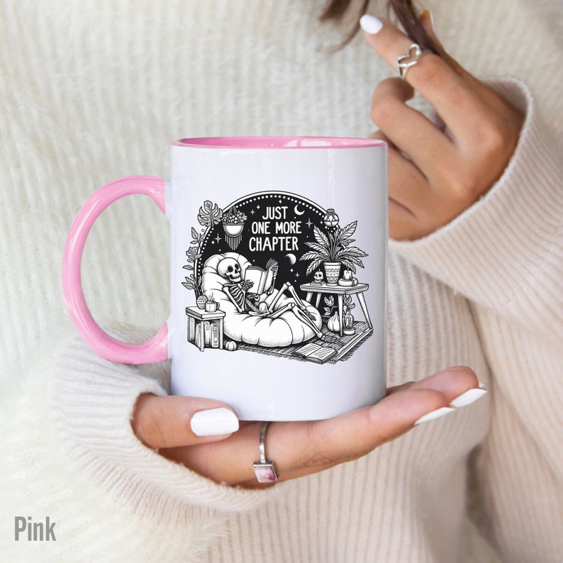 Pink accent coffee mug with skeleton reading while lounging in a boho style room with the words Just One More Chapter