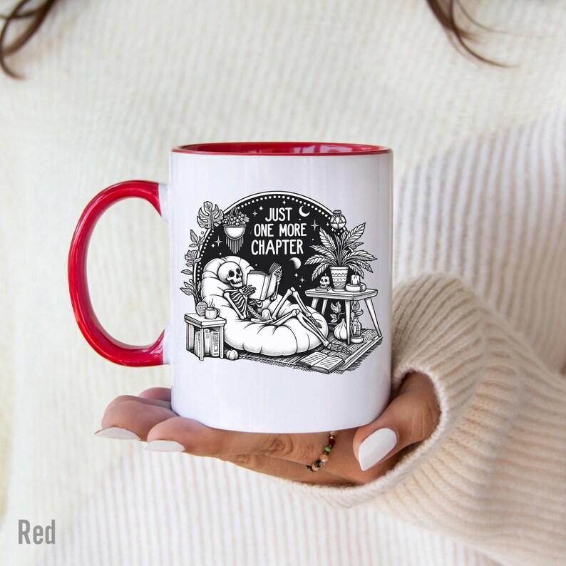 Red accent coffee mug with skeleton reading while lounging in a boho style room with the words Just One More Chapter