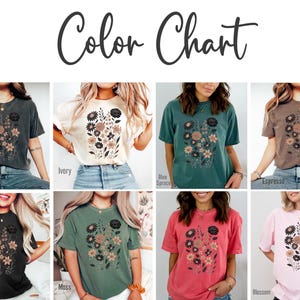 Peut inclure: Un nuancier pr&eacute;sente huit t-shirts, chacun orn&eacute; d'un motif floral. Les chemises sont disponibles en plusieurs couleurs, dont le noir, l'ivoire, le bleu &eacute;pic&eacute;a et le rose. Le texte "Color Chart" est &eacute;crit en police script.