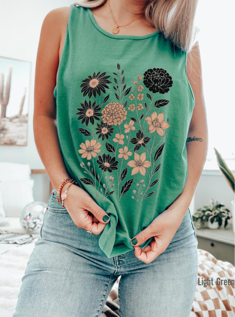 K&ouml;nnte beinhalten: Hellgr&uuml;nes Tanktop mit floralem Design. Die Grafik zeigt schwarze und pfirsichfarbene Blumen mit gr&uuml;nen Stielen und Bl&auml;ttern. Der Text "Light Green" ist in der unteren rechten Ecke sichtbar.