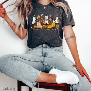 May include: Dark gray heather t-shirt featuring a Halloween-themed graphic. The design includes cartoon cats dressed as ghosts, pumpkins, and scarecrows. The text "Dark Gray Heather" is visible at the bottom left of the image.