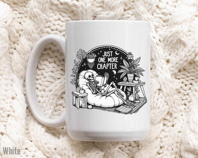 White coffee mug with skeleton reading while lounging in a boho style room with the words Just One More Chapter