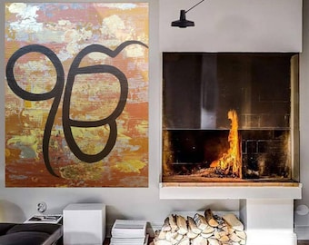 May include: A large abstract painting with a black symbol on a gold and orange background. The painting is hanging on a wall in a room with a fireplace and a wooden floor.