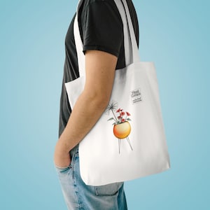 Puede incluir: Bolso tote blanco con una ilustración de una planta en una maceta de estilo moderno de mediados de siglo. La bolsa tiene el texto "Plant Lovers Wonderland Emporium" en un pequeño rectángulo negro.