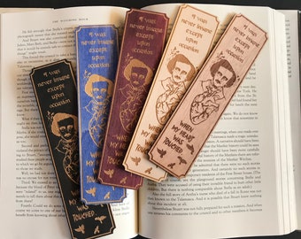Puede incluir: Marcadores de libros de madera con grabados de retratos de Edgar Allan Poe y citas. Los marcadores son de varios colores, incluyendo negro, azul, burdeos y madera natural. Cada marcador tiene un diseño y texto únicos.
