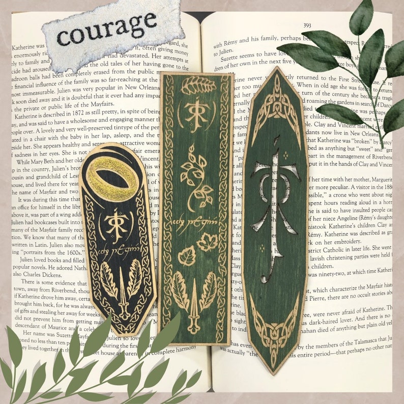 May include: Set of three wooden bookmarks with a Lord of the Rings theme. The bookmarks are green and black with gold accents, featuring iconic imagery and text from the series. The word "courage" is visible.