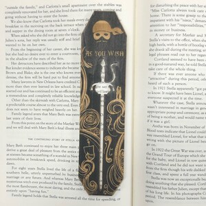 May include: A wooden bookmark with a black and white illustration of a pirate holding a sword. The bookmark is shaped like a coffin and has the text "As You Wish" on it.