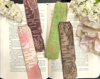 Può includere: Set di cinque segnalibri in legno con disegni intricati di fate e citazioni sul mondo del pianto. I segnalibri sono dipinti in tonalità di verde, rosa, marrone e viola.
