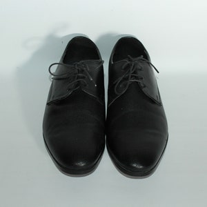 May include: A pair of black leather lace-up shoes with a textured pattern.