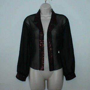 May include: A black sheer blouse with long sleeves and a red sequined trim down the front.
